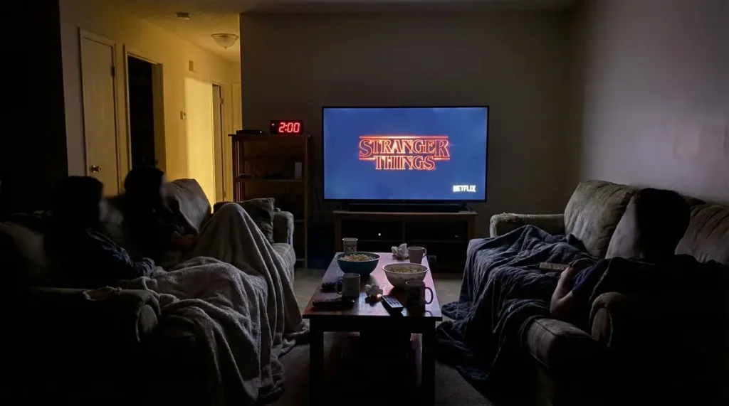Fans regardant Stranger Things en pleine nuit devant écran lumineux